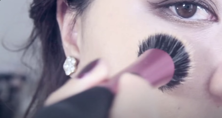 Woman Applying Makeup with a Stippling Brush on Her Fac