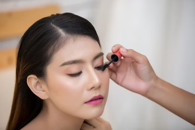 Person applying mascara to another woman